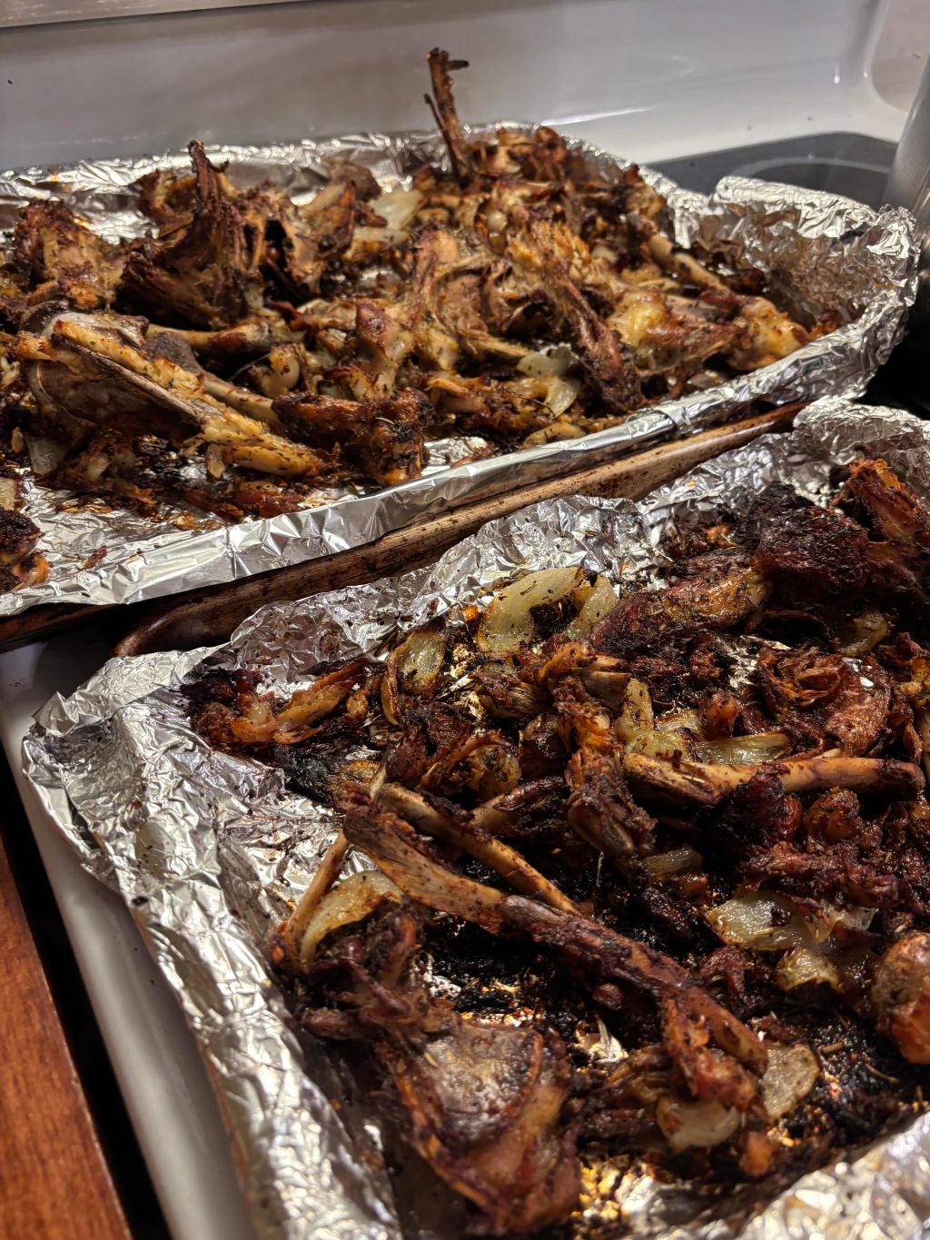 Chicken bones and onions roasted golden brown with herbs in foil pans